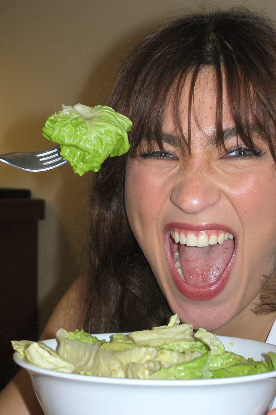 Person laughing maniacally at a bowl of lettuce